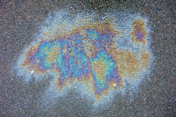 istock Oil Petrol Pollution Leak Rainbow Stain on Pavement 1155854282