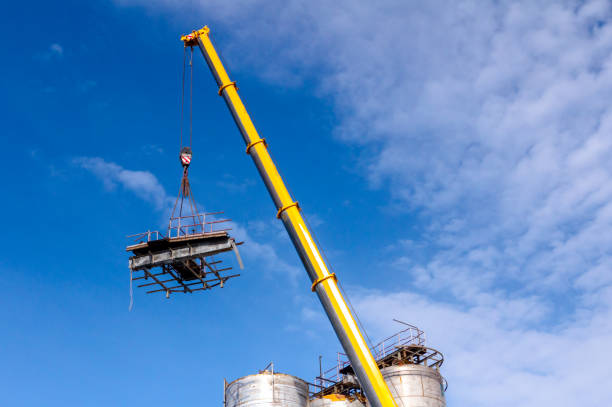 istock Mobile crane lowering part of a big old metal truss 1155860363
