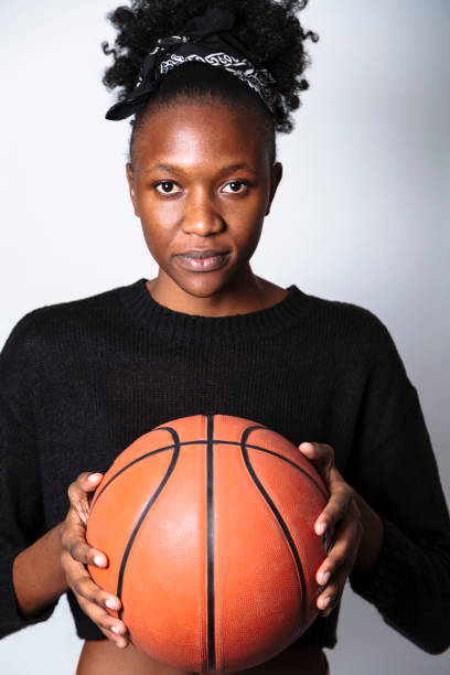istock Young serious black woman holding basket ball 1155860453