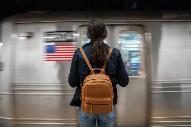 woman waiting for subway - só uma mulher jovem imagens e fotografias de stock