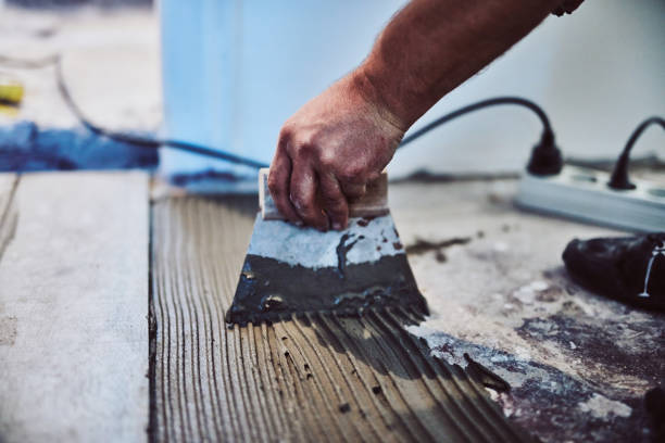 istock Leveling ceramic tiles on a floor. Shallow depth of field. 1155864256