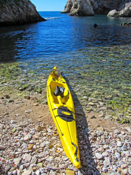 istock One yellow kayak on the pebble beach. 1155864925
