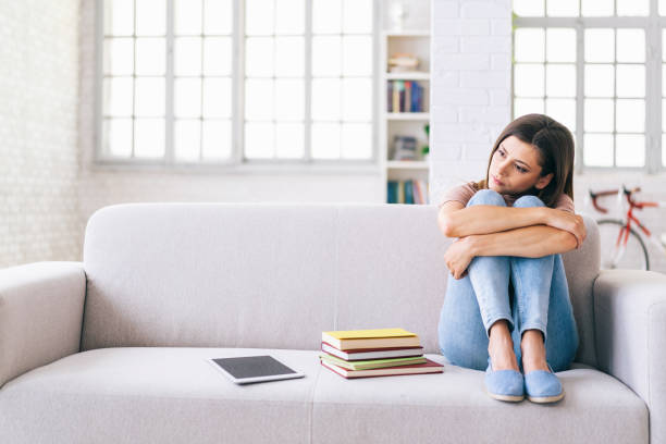 istock Tired woman sitting on a sofa at home 1155865669