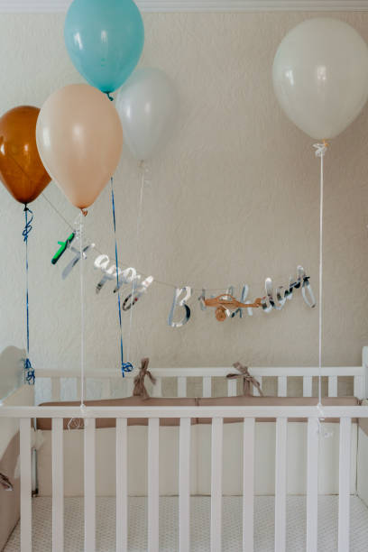 istock White crib decorated with inflated balls 1155865777