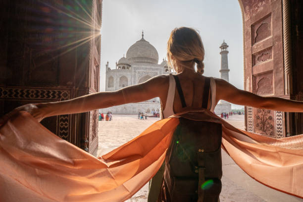 Happy young woman walking and wandering at the famous Taj Mahal at sunrise holding scarf in hands, Agra, India. People travel Asia concept Happy young woman walking and wandering at the famous Taj Mahal at sunrise holding scarf in hands, Agra, India. People travel Asia concept pashmina stock pictures, royalty-free photos & images