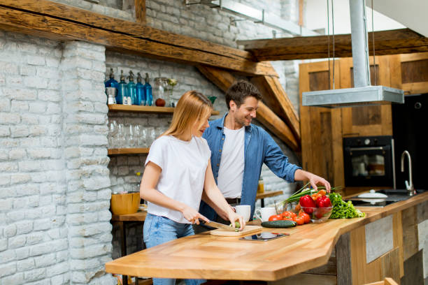 istock Lovely cheerful couple cooking dinner together and having fun at rustic kitchen 1155867512