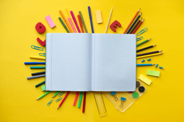 istock Notebook with school supplies on yellow background with copy space 1155867832