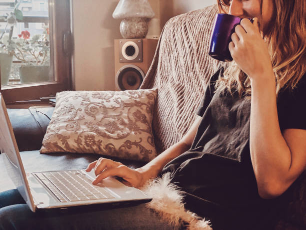 istock Woman using laptop on a home couch. 1155868924