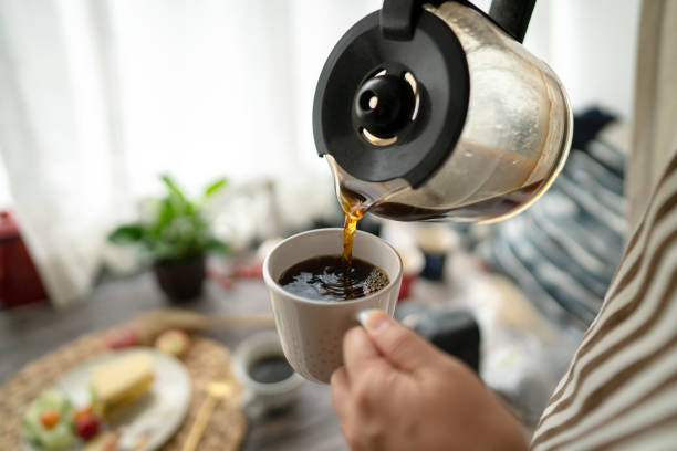 pouring coffee at breakfast stock photo