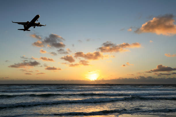 istock flying commercial passenger airplane over seascape with sunset sky 1155869768