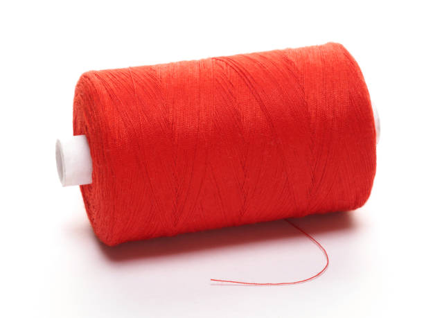 istock Big spool of red threads on a white background 1155870723