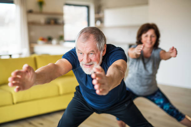 istock A senior couple indoors at home, doing exercise indoors. 1155871090