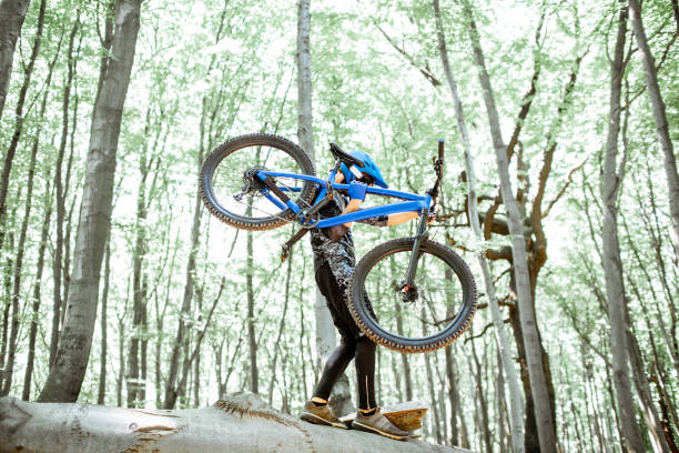 istock Cyclist carrying bicycle while riding extremely in the forest 1155873311