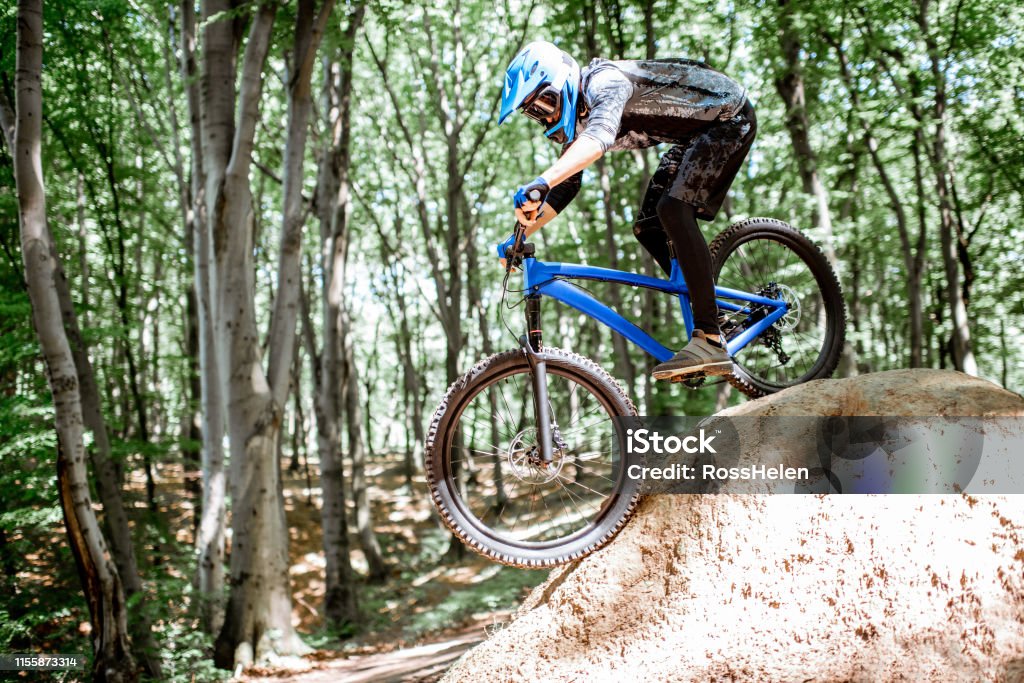 Ciclista cabalgando extremadamente en el bosque - Foto de stock de Motociclista libre de derechos