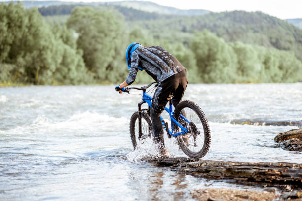 istock Cyclist riding on the rocky riverside 1155873409