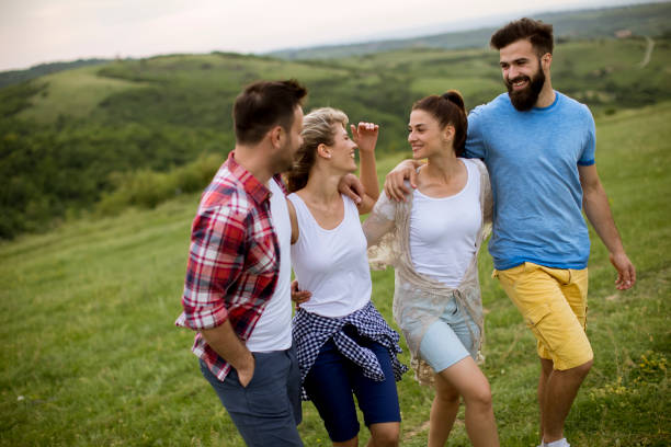 istock Group of young people walking in the summer field 1155874549
