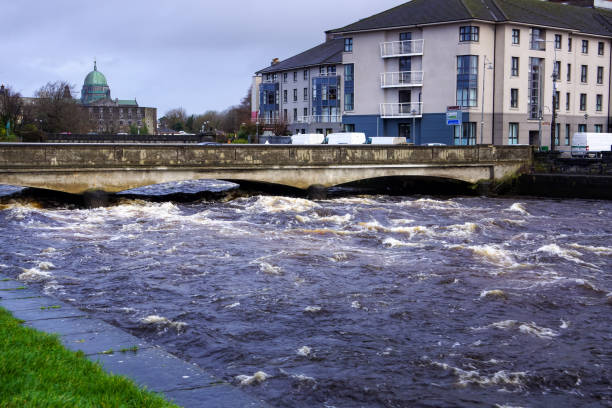 Dangerously strong current on river that about to flood or go over bridge and riverbanks in Galway, Ireland