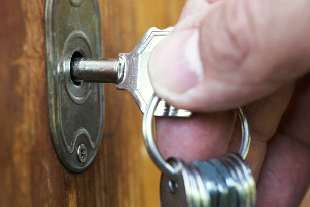 istock Key inserted in a key hole and turned by male fingers 1155876680