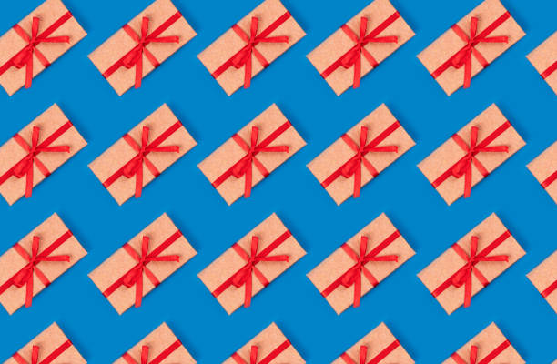 istock Pattern made of simple gift box decorated with red bow ribbon pattern on cyan blue background. Flat lay. 1155876733