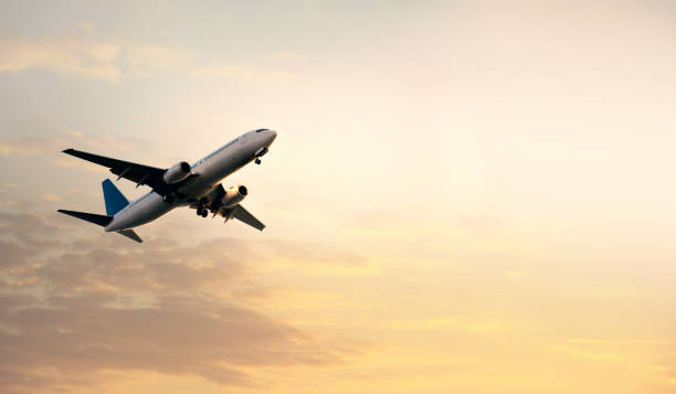 istock flying commercial passenger airplane over orange colored sunset sky 1155877180