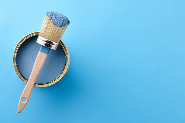 istock Brush and can of blue paint on blue background 1155879851