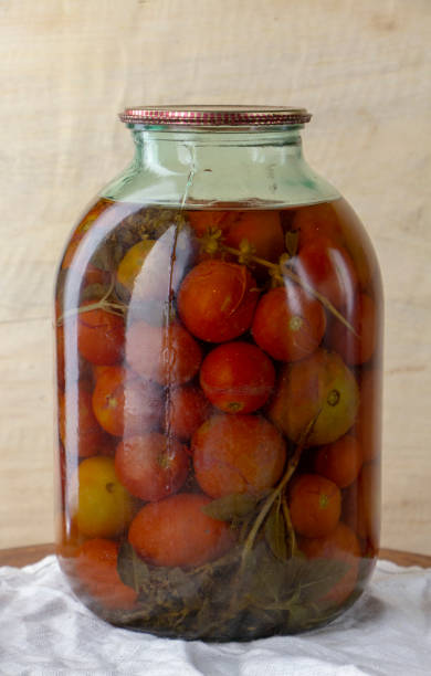 tarro de vidrio de tomates enlatados en un estante de madera en la bodega - relish jar condiment lid fotografías e imágenes de stock