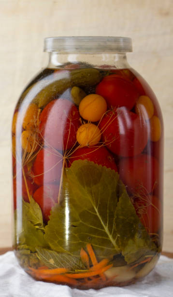 tarro de vidrio de tomates enlatados en un estante de madera en la bodega - relish jar condiment lid fotografías e imágenes de stock