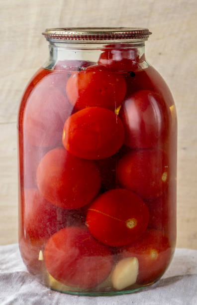 tarro de vidrio de tomates enlatados en un estante de madera en la bodega - relish jar condiment lid fotografías e imágenes de stock