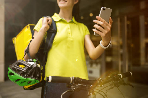 istock Young woman as a courier delivering food using gadgets 1155883972