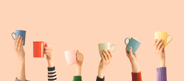 istock Many different arms raised up holding coffee cup 1155884457