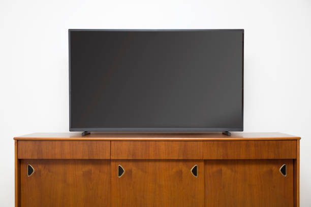 istock Modern TV set with empty blank screen on the wooden cabinet 1155893483