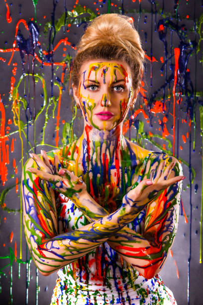 istock Beautiful woman covered with multicolored paints 1155895320