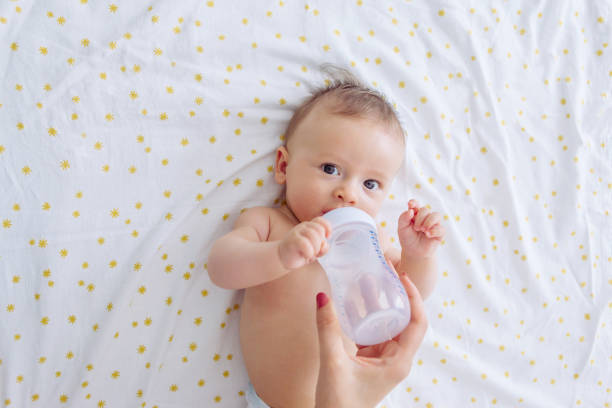 Baby drinking water Mother give baby water from baby bottle, baby likes it 2 5 months stock pictures, royalty-free photos & images