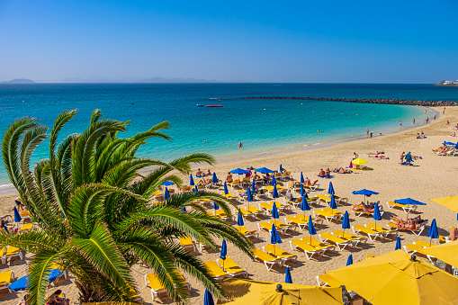 People enjoying a beautiful sunny day on the beach of Playa Blanca, a new and very popular tourist resort located in the south of Lanzarote.