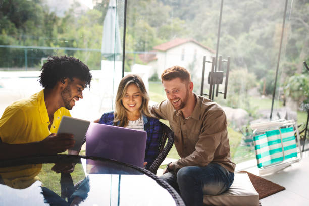 istock Three friends sitting and using laptop and tablet 1155900753