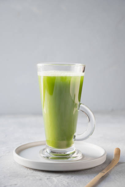 istock Green matcha tea in latte glass on grey table. Space for text. 1155902030