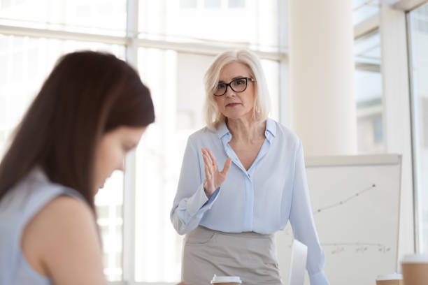 istock Mature female boss scolding intern for bad work results close up 1155902161