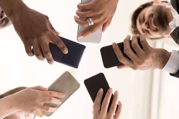 istock Diverse team employees using phones together bottom view 1155902293