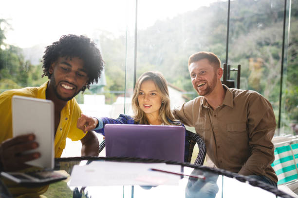 istock Three friends sitting and using laptop and tablet 1155903523