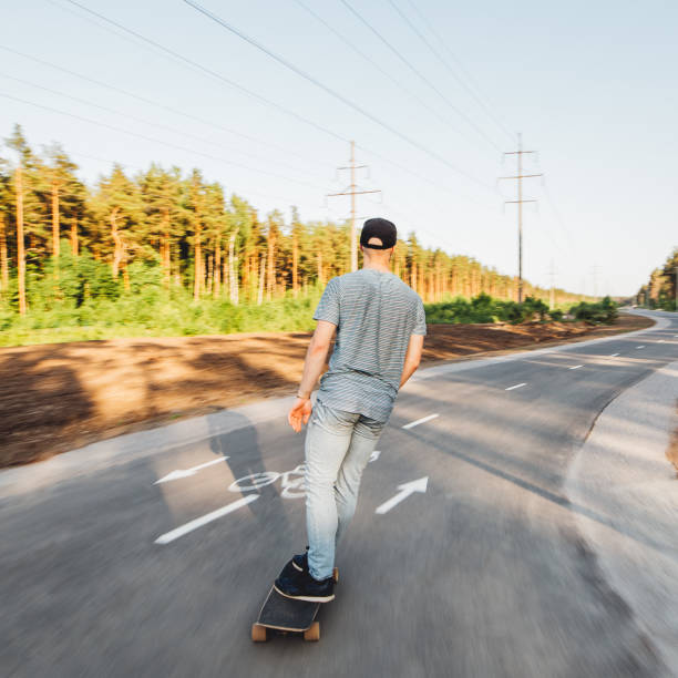 istock Rear view of man longboarding. 1155904394