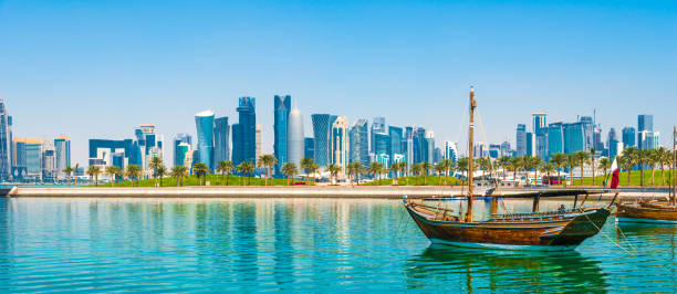 Doha, Qatar - skyline of Doha with dhow Dhow in the bay of Doha overlooking the attractive skyscrapers of the business district dhow photos stock pictures, royalty-free photos & images