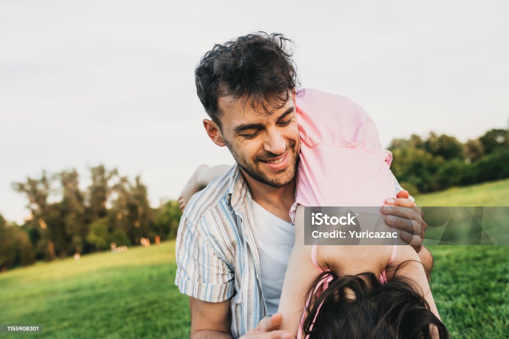 Image of cheerful handsome dad have fun together with his daughter. Happy cute little girl playing with father in the park. Father's Day. Daddy and daughter shares love and enjoy good time together Daughter Stock Photo