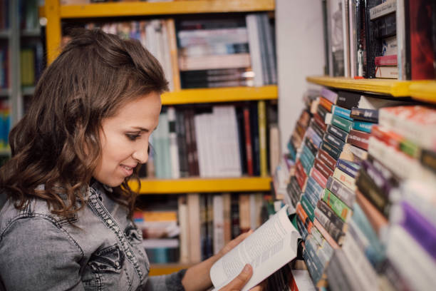 istock Female student picking a book in the bookstore 1155908413