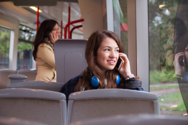 istock Smiling young woman traveling by bus and using mobile phone 1155909582