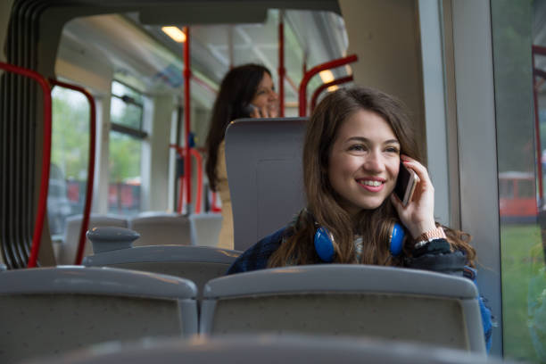 istock Smiling young woman traveling by bus and using mobile phone 1155909863