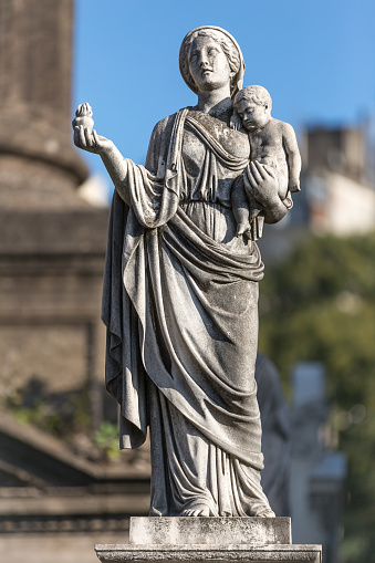 Statue of lady with baby in hand at cemetery