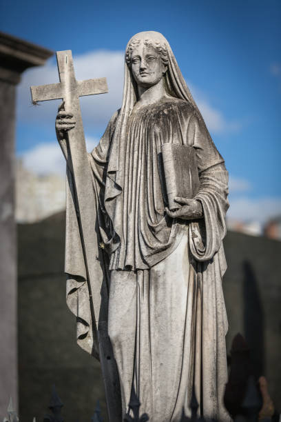 istock Maria with cross and book at cemetery 1155910207
