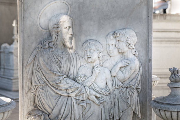 istock Tombstone with Jesus and angels at cemetery 1155910311