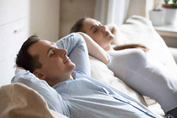 istock Man and woman relaxing on soft comfortable sofa at home 1155911389