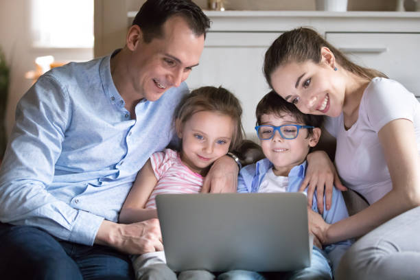 istock Happy family with kids watching funny video on computer screen 1155911394